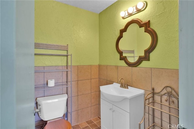 7165 Lyons Ave, Hesperia, CA 92345 - half bath with vanity, tile walls, a textured wall, and a wainscoted wall