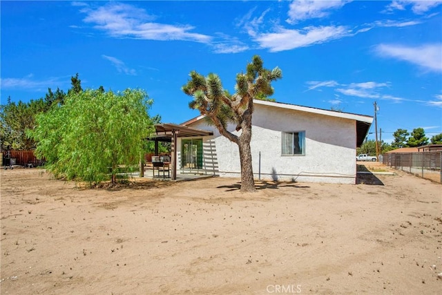 7165 Lyons Ave, Hesperia, CA 92345 - rear view of house with stucco siding, a pergola, and a patio
