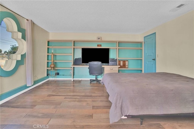 7165 Lyons Ave, Hesperia, CA 92345 - bedroom with wood finished floors, a textured ceiling, and an office area
