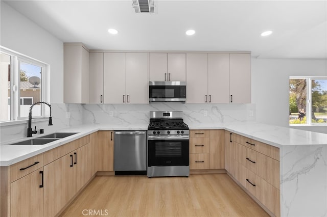 542 N Keystone St, Burbank, CA 91506 - kitchen with stainless steel appliances, light brown cabinets, a peninsula, light stone countertops, and light wood-type flooring