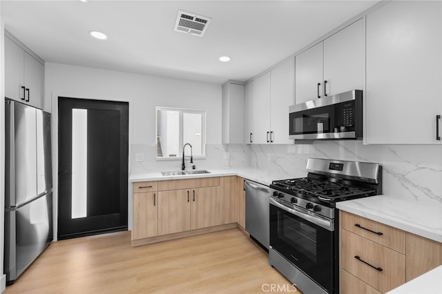 542 N Keystone St, Burbank, CA 91506 - kitchen featuring appliances with stainless steel finishes, light wood-style floors, light brown cabinetry, decorative backsplash, and recessed lighting