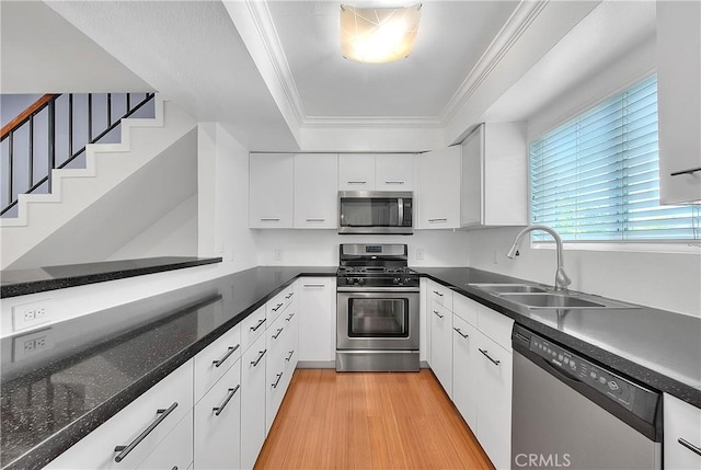11154 Huston St Unit 7, North Hollywood, CA 91601 - kitchen with stainless steel appliances, white cabinetry, ornamental molding, a tray ceiling, and dark countertops