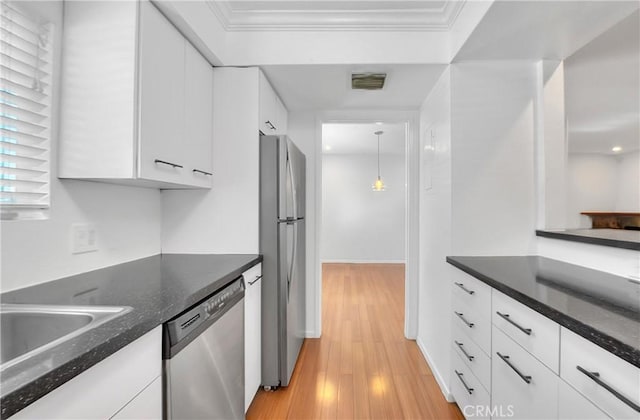 11154 Huston St Unit 7, North Hollywood, CA 91601 - kitchen featuring appliances with stainless steel finishes, white cabinetry, crown molding, light wood-type flooring, and dark stone counters