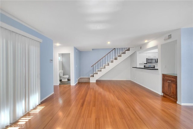 11154 Huston St Unit 7, North Hollywood, CA 91601 - unfurnished living room with stairway, light wood-type flooring, and recessed lighting
