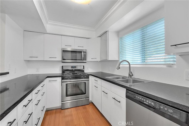 11154 Huston St Unit 7, North Hollywood, CA 91601 - kitchen featuring stainless steel appliances, white cabinetry, ornamental molding, dark countertops, and light wood-style floors