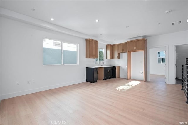 5836 Ernest Ave, Los Angeles, CA 90034 - kitchen with light wood finished floors, light countertops, brown cabinetry, and recessed lighting
