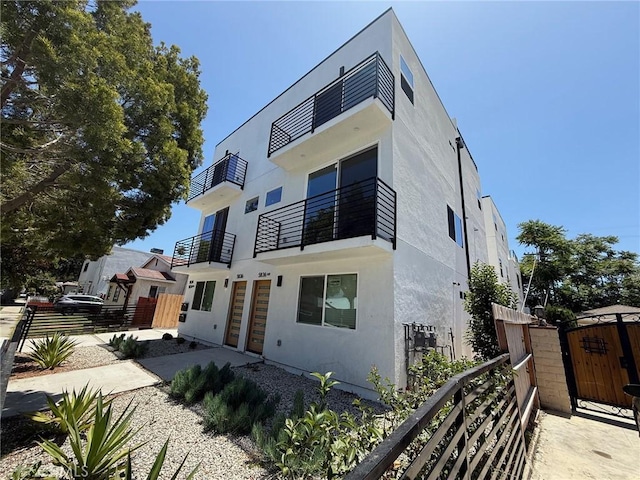 5836 Ernest Ave, Los Angeles, CA 90034 - contemporary house featuring a gate, stucco siding, and a balcony