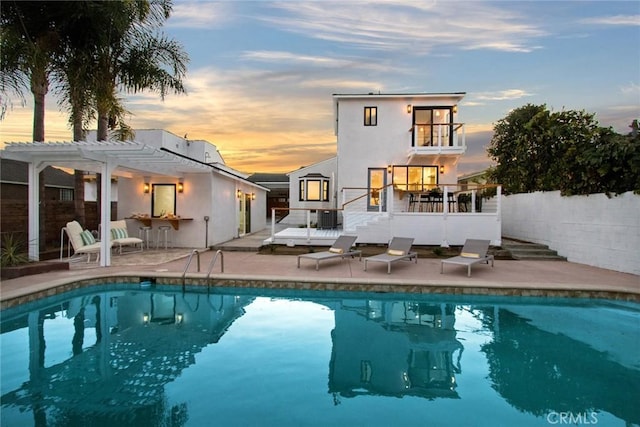 5126 Chesley Ave, Los Angeles, CA 90043 - back of property at dusk featuring a pergola, a patio, stucco siding, and stairway