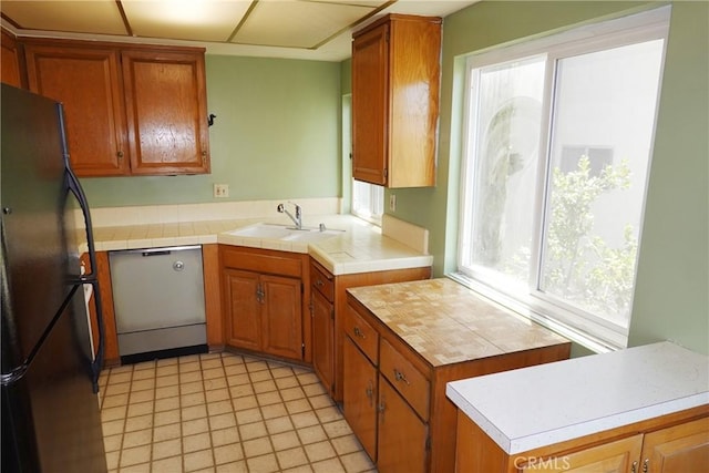 1754 N Kenmore Ave Unit 201, Los Angeles, CA 90027 - kitchen featuring freestanding refrigerator, dishwasher, light countertops, brown cabinets, and light tile patterned floors