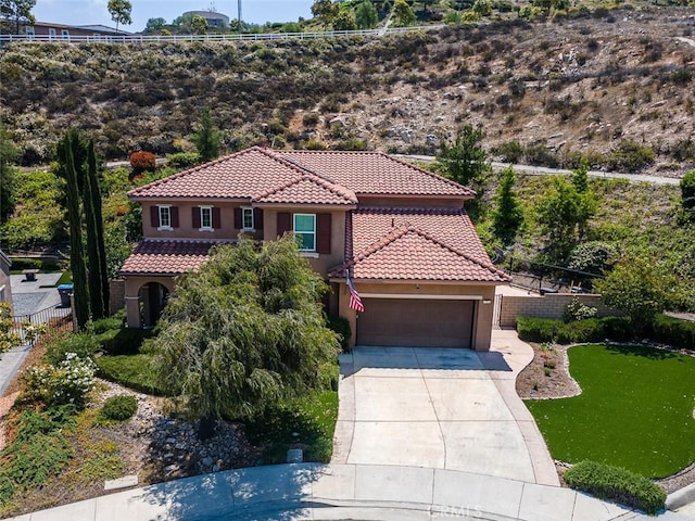 17122 Broken Rock Ct, Riverside, CA 92503 - mediterranean / spanish home featuring a tile roof, stucco siding, an attached garage, and concrete driveway
