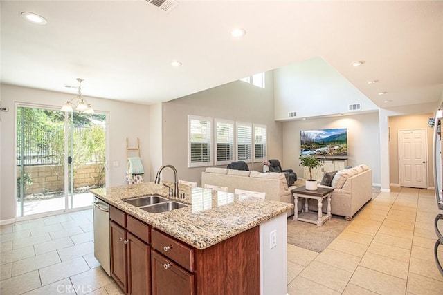17122 Broken Rock Ct, Riverside, CA 92503 - kitchen with stainless steel dishwasher, light tile patterned floors, a center island with sink, light stone counters, and pendant lighting