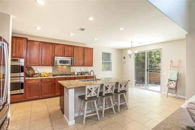 17122 Broken Rock Ct, Riverside, CA 92503 - kitchen with appliances with stainless steel finishes, light stone counters, tasteful backsplash, light tile patterned floors, and recessed lighting
