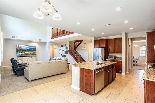 17122 Broken Rock Ct, Riverside, CA 92503 - kitchen with appliances with stainless steel finishes, recessed lighting, open floor plan, light stone countertops, and a center island with sink