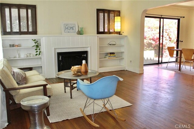 907 E Poppyfields Dr E, Altadena, CA 91001 - living area featuring a fireplace, arched walkways, wood finished floors, and built in features