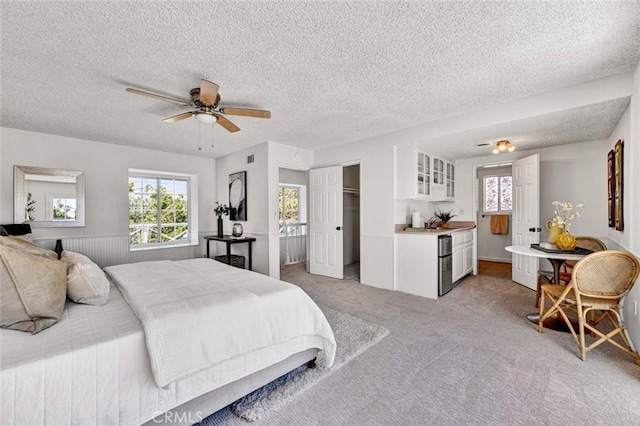 1428 E Adams Ave, Orange, CA 92867 - bedroom featuring multiple windows, light colored carpet, freestanding refrigerator, a textured ceiling, and ceiling fan