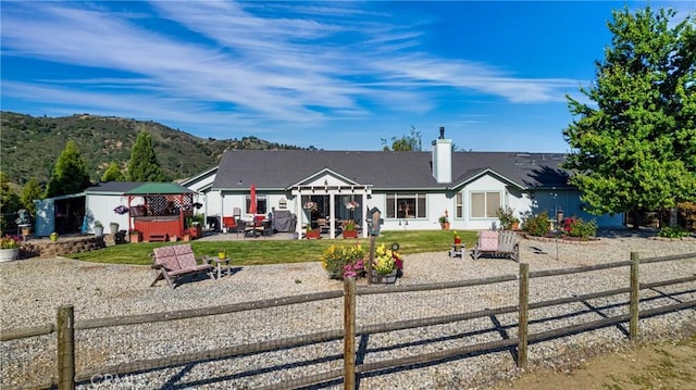 23220 Lakeview Dr, Tehachapi, CA 93561 - view of front of property with a hot tub, a fenced backyard, a patio area, and a chimney