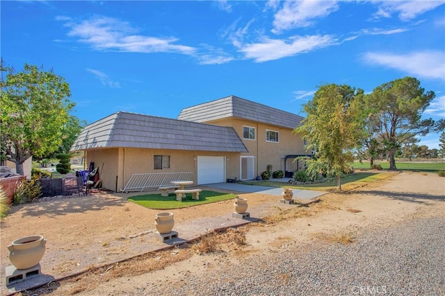 15037 Wildflower Ln, Helendale, CA 92342 - view of front of property with a garage, mansard roof, stucco siding, and driveway