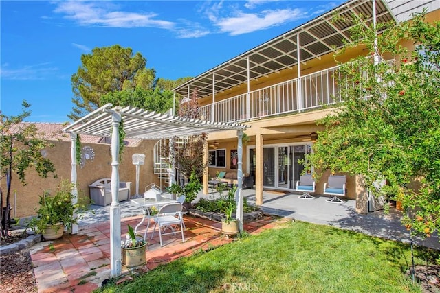 15037 Wildflower Ln, Helendale, CA 92342 - back of house featuring a pergola, a patio area, stucco siding, and a balcony