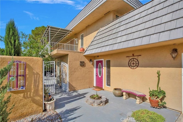 15037 Wildflower Ln, Helendale, CA 92342 - doorway to property with stucco siding, a gate, and a balcony