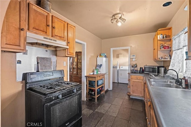 1636 W 70th St, Los Angeles, CA 90047 - kitchen with black gas stove, stainless steel microwave, under cabinet range hood, open shelves, and washing machine and clothes dryer