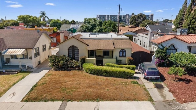 1636 W 70th St, Los Angeles, CA 90047 - mediterranean / spanish house with a residential view, stucco siding, and concrete driveway