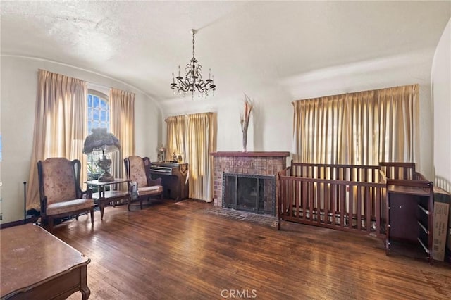 1636 W 70th St, Los Angeles, CA 90047 - living room featuring a chandelier, wood finished floors, lofted ceiling, and a brick fireplace