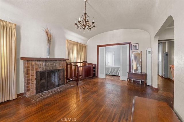 1636 W 70th St, Los Angeles, CA 90047 - living room with hardwood / wood-style flooring, lofted ceiling, a chandelier, arched walkways, and a fireplace