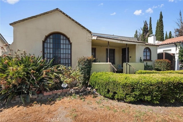 1636 W 70th St, Los Angeles, CA 90047 - mediterranean / spanish home featuring stucco siding and a chimney