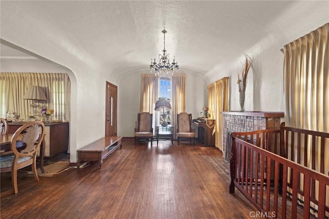 1636 W 70th St, Los Angeles, CA 90047 - sitting room featuring hardwood / wood-style floors, lofted ceiling, arched walkways, a textured ceiling, and a chandelier