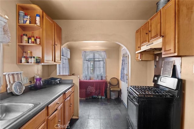 1636 W 70th St, Los Angeles, CA 90047 - kitchen with black gas range oven, under cabinet range hood, arched walkways, open shelves, and brown cabinetry