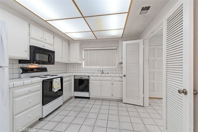 5081 Blackpool Rd, Westminster, CA 92683 - kitchen with dishwasher, white electric range oven, tile counters, black microwave, and white cabinets