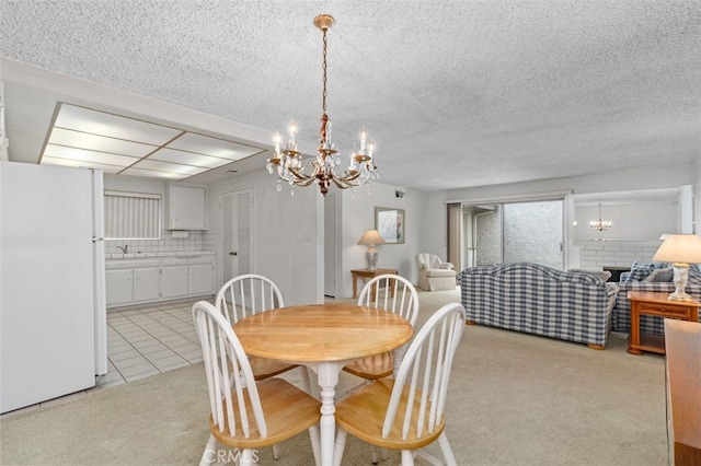 5081 Blackpool Rd, Westminster, CA 92683 - dining area with a chandelier, light carpet, a textured ceiling, and light tile patterned floors
