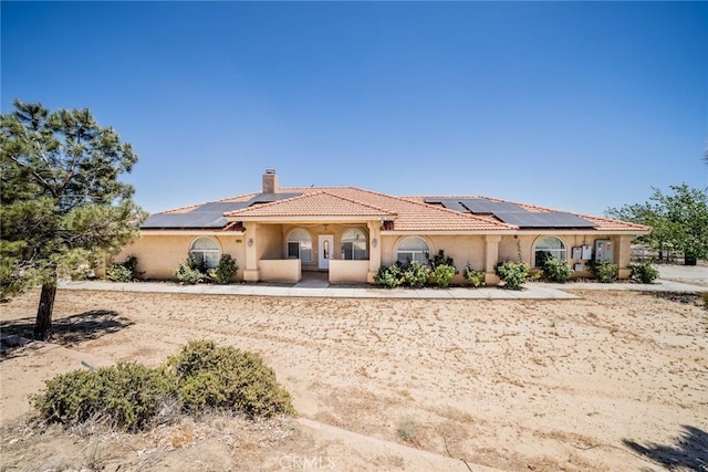 8225 Ailanthus St, Phelan, CA 92371 - mediterranean / spanish-style house with solar panels, a chimney, stucco siding, and a tiled roof