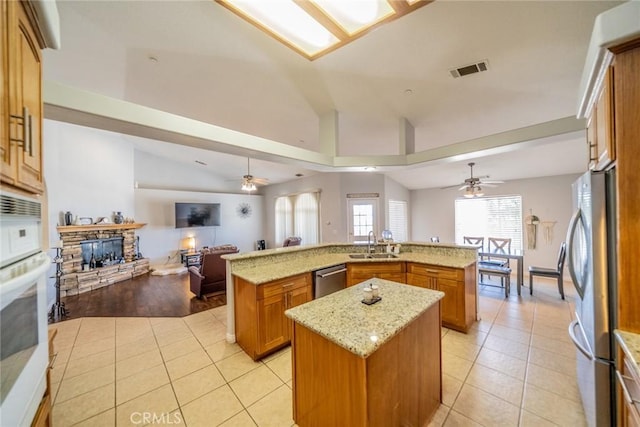 8225 Ailanthus St, Phelan, CA 92371 - kitchen with a large island with sink, a ceiling fan, open floor plan, appliances with stainless steel finishes, and brown cabinets