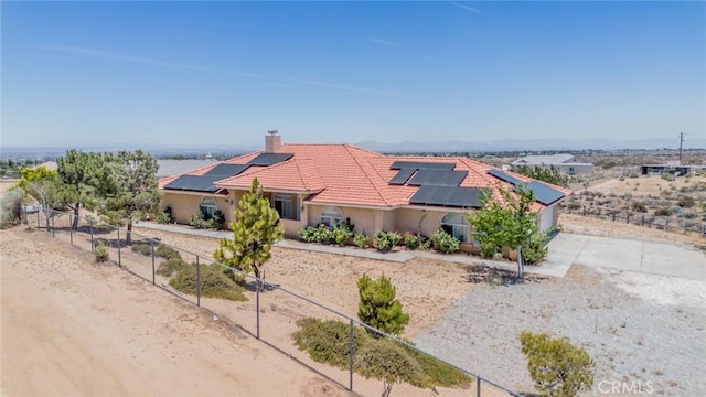 8225 Ailanthus St, Phelan, CA 92371 - mediterranean / spanish house featuring solar panels, a tiled roof, stucco siding, a chimney, and concrete driveway
