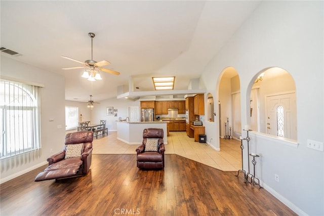 8225 Ailanthus St, Phelan, CA 92371 - living area with ceiling fan, light wood-type flooring, arched walkways, and lofted ceiling