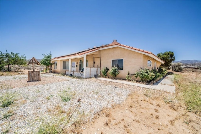 8225 Ailanthus St, Phelan, CA 92371 - back of house featuring solar panels, stucco siding, and a tile roof