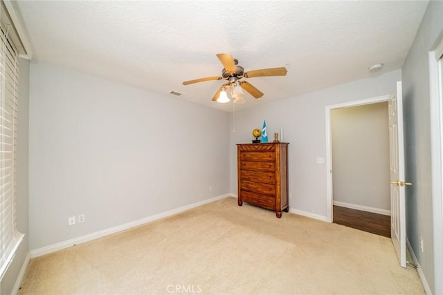 8225 Ailanthus St, Phelan, CA 92371 - bedroom with light colored carpet, ceiling fan, and a textured ceiling