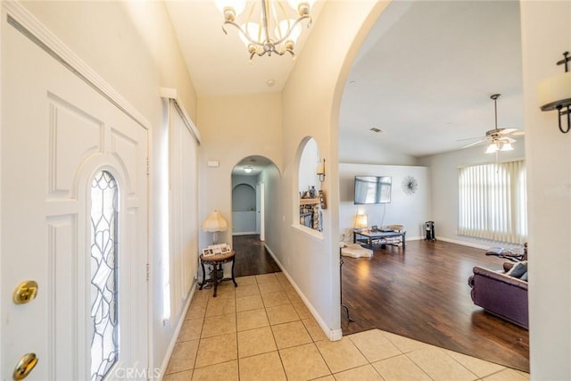 8225 Ailanthus St, Phelan, CA 92371 - entrance foyer with light tile patterned flooring, arched walkways, lofted ceiling, ceiling fan, and a chandelier