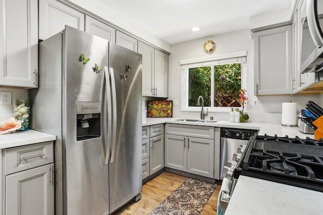 247 Currant Way, Oceanside, CA 92057 - kitchen featuring appliances with stainless steel finishes, gray cabinetry, light countertops, light wood-style flooring, and recessed lighting