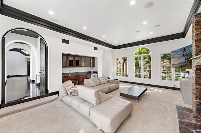 30372 Marbella Vis, San Juan Capistrano, CA 92675 - carpeted living room featuring arched walkways, bar with sink, recessed lighting, a raised ceiling, and crown molding