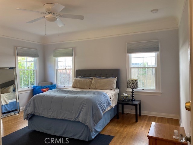 667 S Bronson, Los Angeles, CA 90005 - bedroom featuring multiple windows, wood finished floors, and a ceiling fan