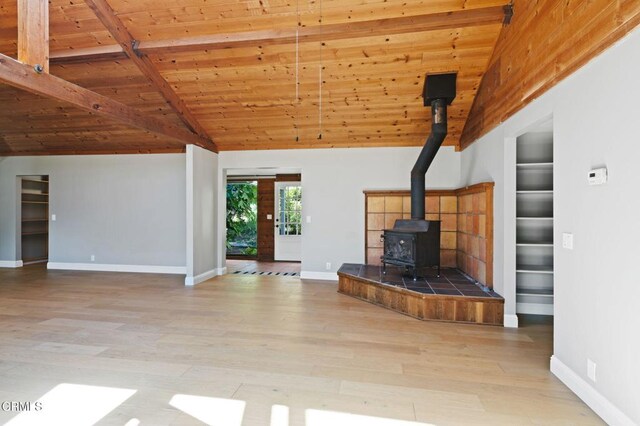 7950 Flynn Creek Rd, Comptche, CA 95427 - unfurnished living room with wood ceiling, a wood stove, wood finished floors, and built in shelves