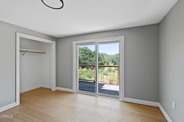 7950 Flynn Creek Rd, Comptche, CA 95427 - unfurnished bedroom featuring light wood finished floors, a closet, and access to exterior