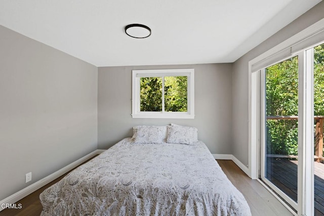 7950 Flynn Creek Rd, Comptche, CA 95427 - bedroom with multiple windows, wood finished floors, and access to outside