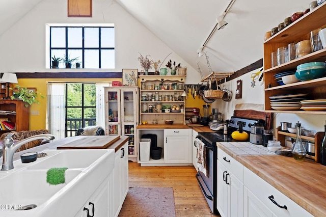 7950 Flynn Creek Rd, Comptche, CA 95427 - kitchen featuring stainless steel range with electric stovetop, open shelves, vaulted ceiling, white cabinets, and light wood finished floors