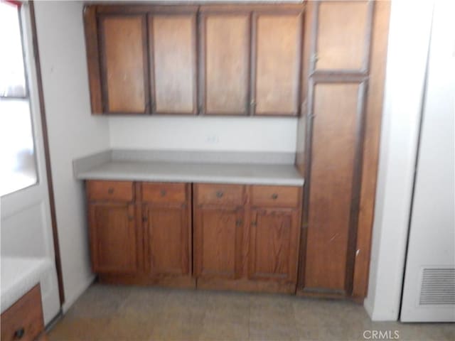 3250 Apple Ave, Jurupa Valley, CA 92509 - kitchen featuring brown cabinets, light countertops, and light tile patterned flooring
