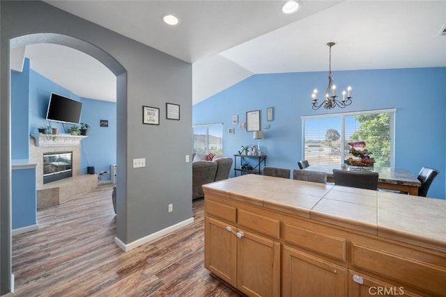 1681 Ocean St, Oceano, CA 93445 - kitchen featuring tile countertops, arched walkways, lofted ceiling, open floor plan, and wood finished floors