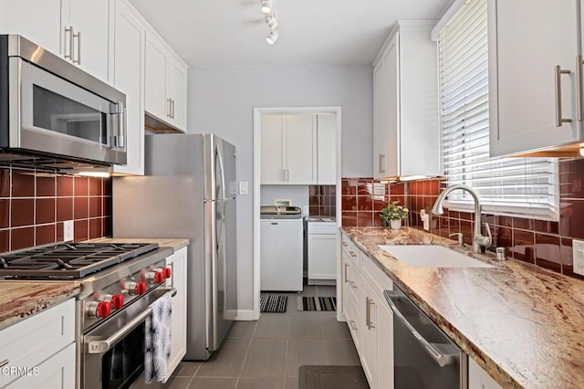 324 N J St, Oxnard, CA 93030 - kitchen with stainless steel appliances, tile patterned flooring, white cabinetry, and decorative backsplash