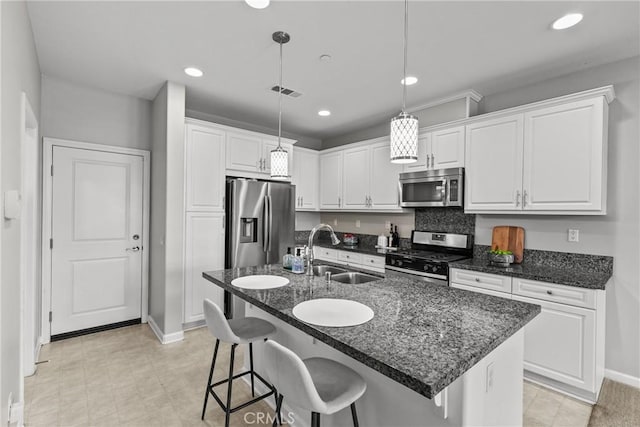 2894 E Via Fiano, Ontario, CA 91764 - kitchen with appliances with stainless steel finishes, white cabinets, a kitchen breakfast bar, recessed lighting, and hanging light fixtures